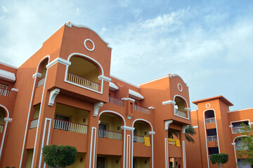 Fragment of red brick resort hotel exterior under blue summer sky