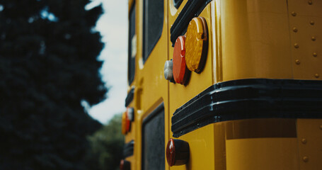 Rear view school bus yellow red headlights close up. Stop lights on schoolbus.