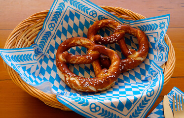 Delicious traditional Bavarian Brezeln or pretzels with a brown salty crust on a traditional Bavarian cocktail napkin in a basket at the Bavarian Oktoberfest (Munich, Bavaria, Germany)