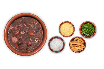 Delicious feijoada bowl with side dishes. Brazilian typical cuisine made with black beans and pork on white isolated background.