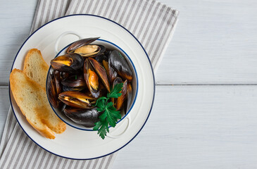 Fresh, Boiled mussels, Black Sea, with white bread, on a white wooden table, no people,