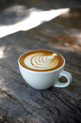 Close up of Hot coffee with heart shape latte art on wooden table                               