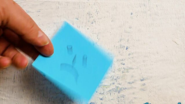 Men hand changes blue sticker with sad face on the wall to orange sticky note with smiling face