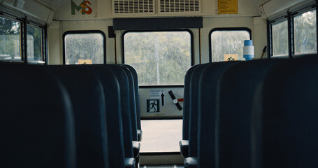 Interior school bus staying empty on parking close up. Vehicle comfortable seats