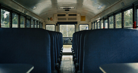 Empty school bus saloon with blue seats close up. View aisle inside transport.  © stockbusters