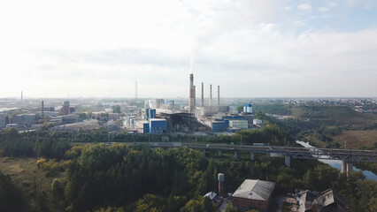 Fototapeta na wymiar Industrial area and smoking chimney on power plant near the city. landscape. Stock footage. Smoke staks from boiler pipes on heating plant, aerial view, ecology concept.