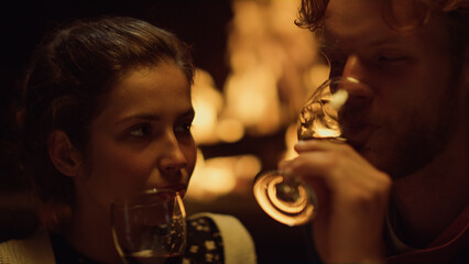 Relaxed couple drink red wine at evening. Romantic lovers celebrate honeymoon