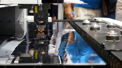 Industrial laser machine cutting metal, robotic mechanism sample at the international exhibition,...