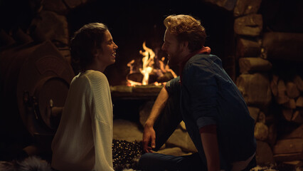 Cozy lovers rest fireplace in country house. Lovely couple flirting at date.