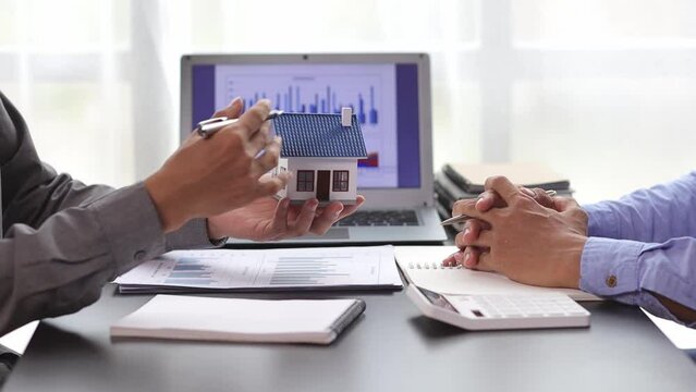 Businessmen discuss real estate project ideas and plan budget allocations to maximize profits. Real estate agents who are talking about homes are offering customers the prices of housing projects.