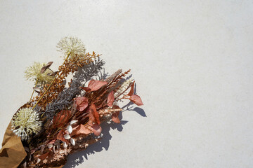 A bouquet of dried flowers in craft paper on a white background with copy space