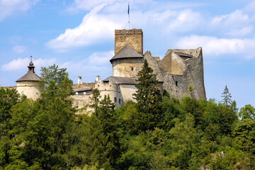 An old castle on the hill next on the clear day, some clouds in the background