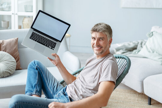 happy man showing his new laptop. side view.