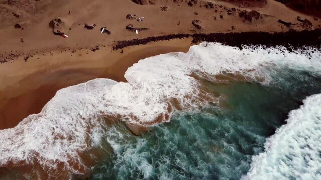 Aerial drone footage of the waves washing the sandy beach at Cotillo, Fuerteventura, Spain