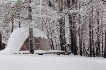 Glamping area with dome tent in the snowy winter outdoors