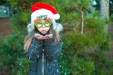 little girl in a winter park,smiling girl with santa hat in the forest has fun