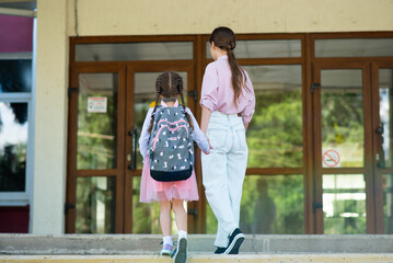 First day at school. Older sister leads a little school girl in first grade. Back to school.