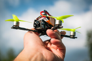 Small FPV drone close-up in a man's hand