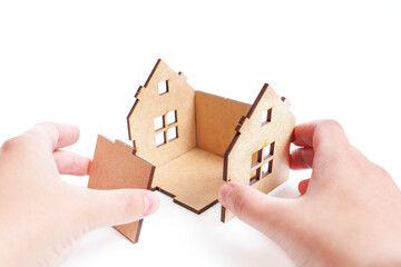 Assembling a wooden house kit on white