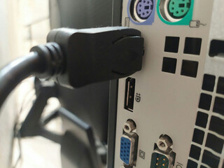 View of the rear of a PC computer, attached cables. Using DisplayPort for a PC Monitor. Blurred background