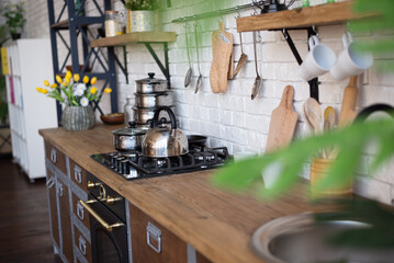 The picture shows the kitchen interior. Kitchen table, pots, a kettle, ladles and other various utensils. Background for recipes.