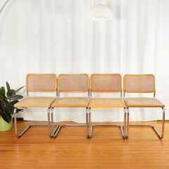 Straight on view of Set of Chrome & Cane Cantilever Cesca Chairs on wood floor before luxurious white curtains