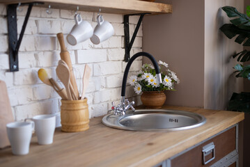 The picture shows the kitchen interior. Kitchen table, pots, a kettle, ladles and other various...