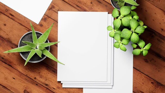 Mockup white paper on the wooden brown table background with tropical house plants ,top view.