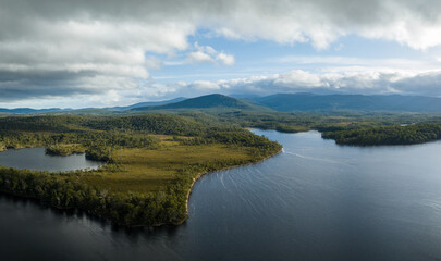 Fototapeta na wymiar Aerial top down footage of a windy river, in the Tasmania wilderness. Lake with a Sandy beach and trees in Australia