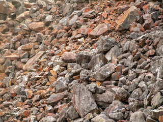 Falun Copper Mine the World Heritage with orange mountain visible with lots of rocks stones and slag