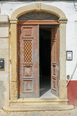 Fototapeta na wymiar Velha porta aberta de uma cidade portuguesa.