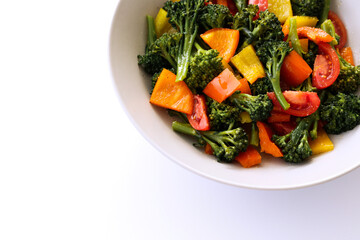 Tasty salad with steamed broccoli and fresh tomatoes in a white ceramic bowl. Clean eating concept. Healthy vegan dish made of organic vegetables. Close up, copy space, background.