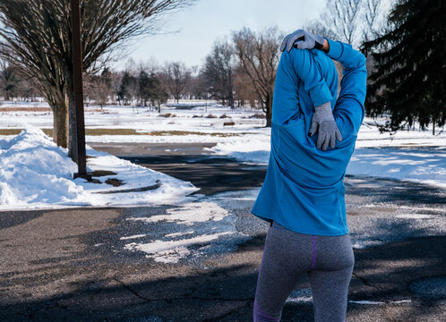 Woman warming up, stretching her  arms before her early morning exercise at winter day.  Healthy and Lifestyle Concept.