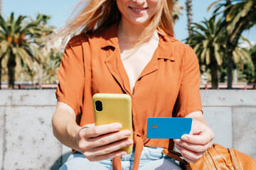 unrecognizable caucasian woman holding smart phone and credit card. Concept of online shopping
