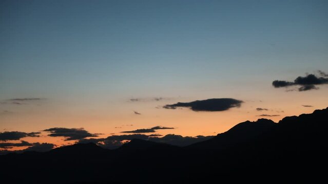 Sunset and little moon and clouds at evening in the alps