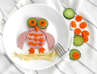 Funny edible owl bird made of sausage, carrots, cucumbers for breakfast for kids. the concept of food art, children's food