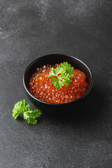 Salmon caviar with parsley in a bowl