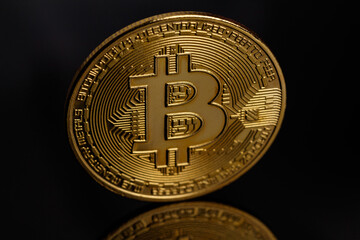 Cryptocurrency market concept. Cryptocurrency - bitcoin coin. Bitcoin is the coin of the future. Bitcoin and its reflection. Gold coin on a black background. Trading. Macro photography. Close-up.