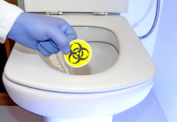 A toilet or bathroom with the biohazard symbol against fecal microbes