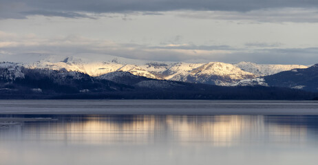 Obraz na płótnie Canvas View of a frozen Yellowstone Lake with snow covered mountains in American Landscape. Yellowstone National Park. United States. Nature Background.