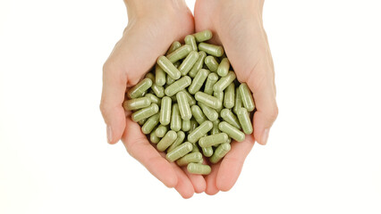 Female hands hold green capsule with superfoods moringa or spirulina, isolated on white background