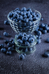 Blueberries organic natural berry on dark background. Blueberry in glass bowl plate.
