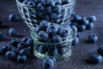 Blueberries organic natural berry with water drops on dark background close-up. Blueberry in glass...