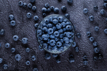 Blueberry in glass plate top view. Blueberries organic natural berry with water drops on dark background.