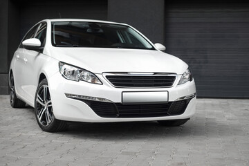 Compact white executive car, with beautiful wheels, large chrome grille. Modern white car. - obrazy, fototapety, plakaty
