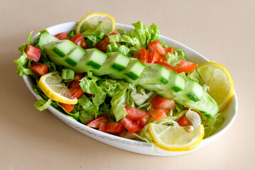 Green salad with arugula, lamb and tomatoes. Healthy vegan dish. Top view at table. Turkish Coban (choban) salata or Shepherds salad, Akdeniz salad in white bowl.