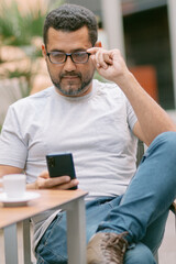 handsome businessman sending message with his smartphone in city