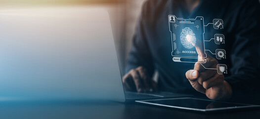 Businessman with a laptop, hologram icon fingerprint encryption, protecting access to confidential information by using fingerprint technology. Fingerprint encryption concept.