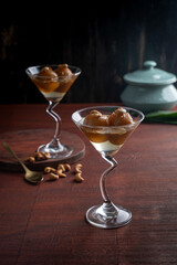Indian sweet Gulab Jamun with almond and cashew nut served in a goblets isolated on dark background side view of fastfood