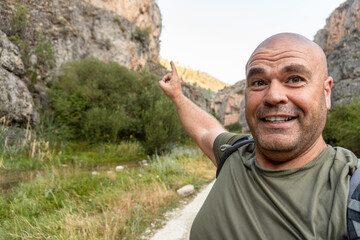 Male hiker takes a selfie smiling in a natural setting